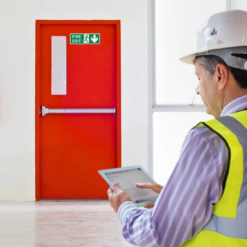 Inspector reviewing a fire exit door on a tablet